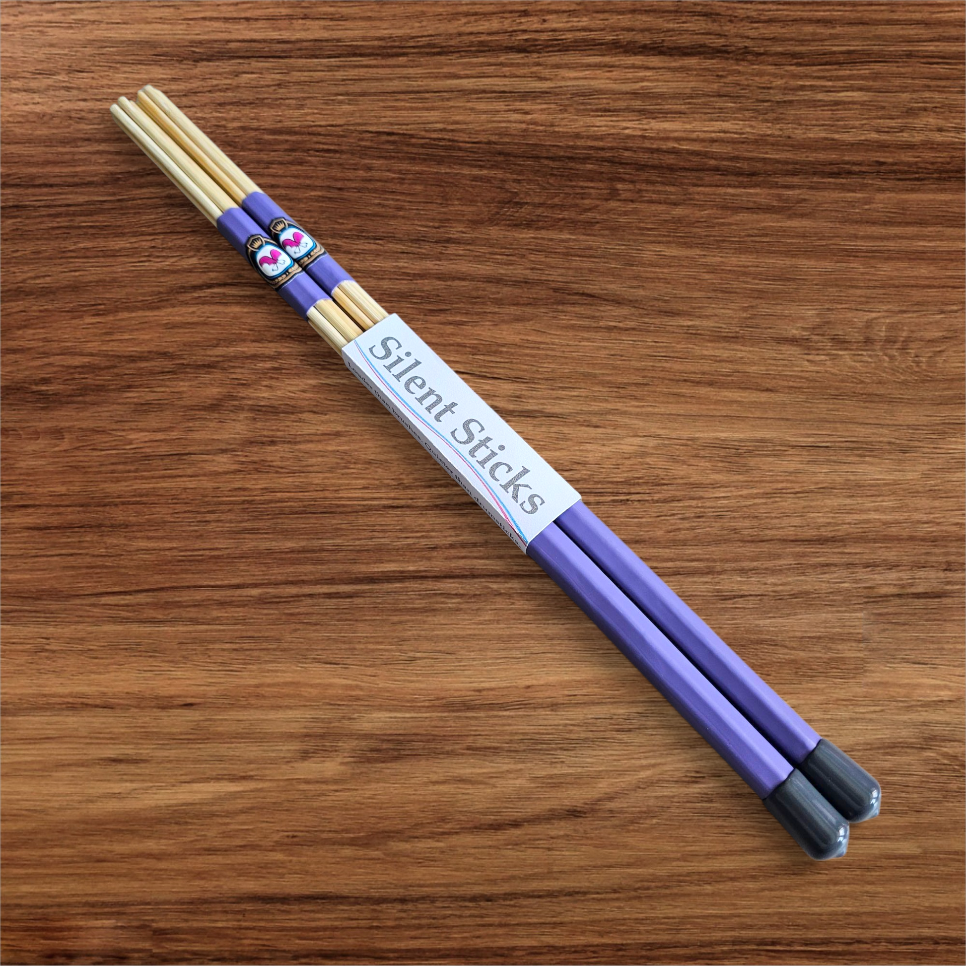 A single pair of custom Silent Sticks 7-dowel hot rod drumsticks with purple grip and grey end caps. Low volume practice drum rods for apartments and low-volume acoustic gigs.
