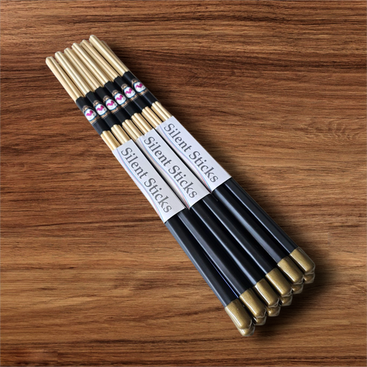 A brick containing 6 pairs of Silent Sticks 7-dowel hot rod drumsticks with black grip and gold end caps. Low volume practice drum rods for apartments and low-volume acoustic gigs.