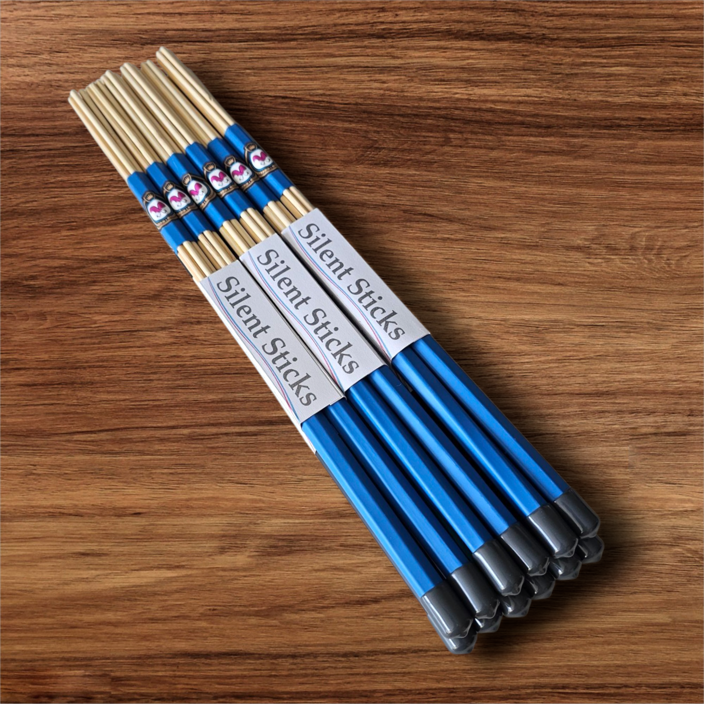 A brick containing 6 pairs of Silent Sticks 7-dowel hot rod (rute) drumsticks with blue grip and grey end caps. Low volume practice drum rods for apartments and low-volume acoustic gigs.