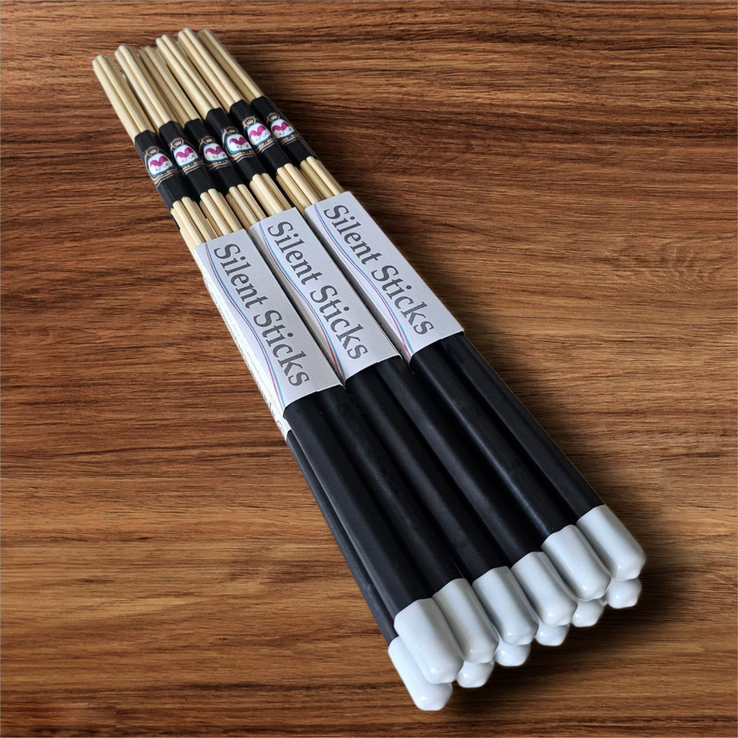 A brick containing 6 pairs of Silent Sticks 7-dowel hot rod (rute) drumsticks with black grip and white end caps. Low volume practice drum rods for apartments and low-volume acoustic gigs.