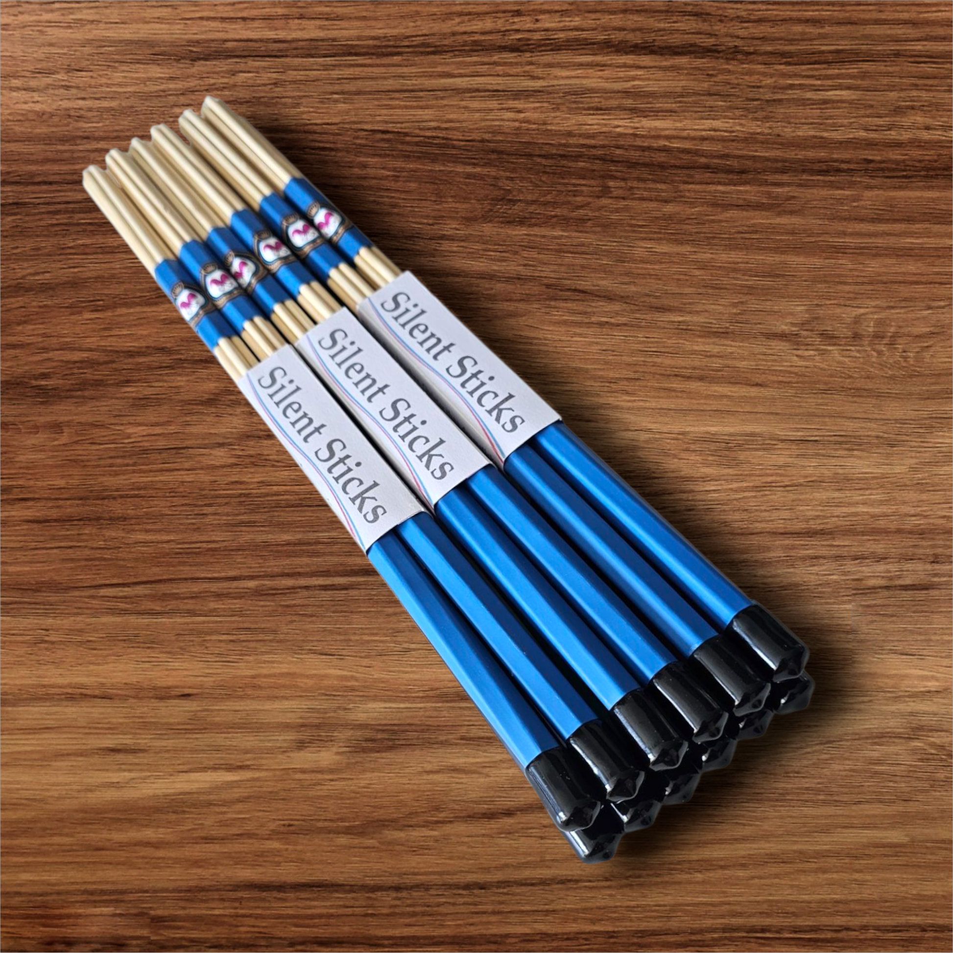 A brick containing 6 pairs of Silent Sticks 7-dowel hot rod (rute) drumsticks with blue grip and black end caps. Low volume practice drum rods for apartments and low-volume acoustic gigs.