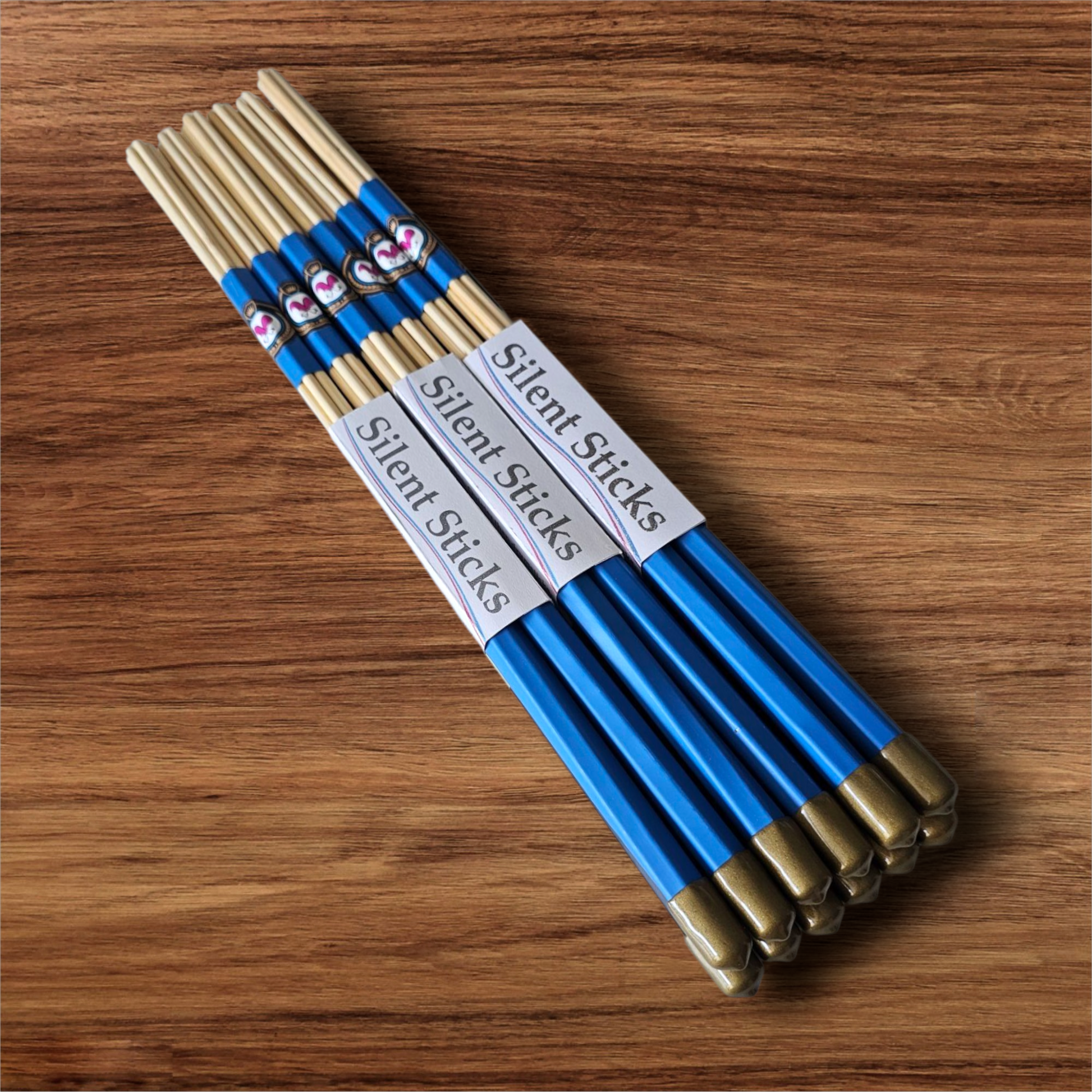 A brick containing 6 pairs of Silent Sticks 7-dowel hot rod (rute) drumsticks with blue grip and gold end caps. Low volume practice drum rods for apartments and low-volume acoustic gigs.