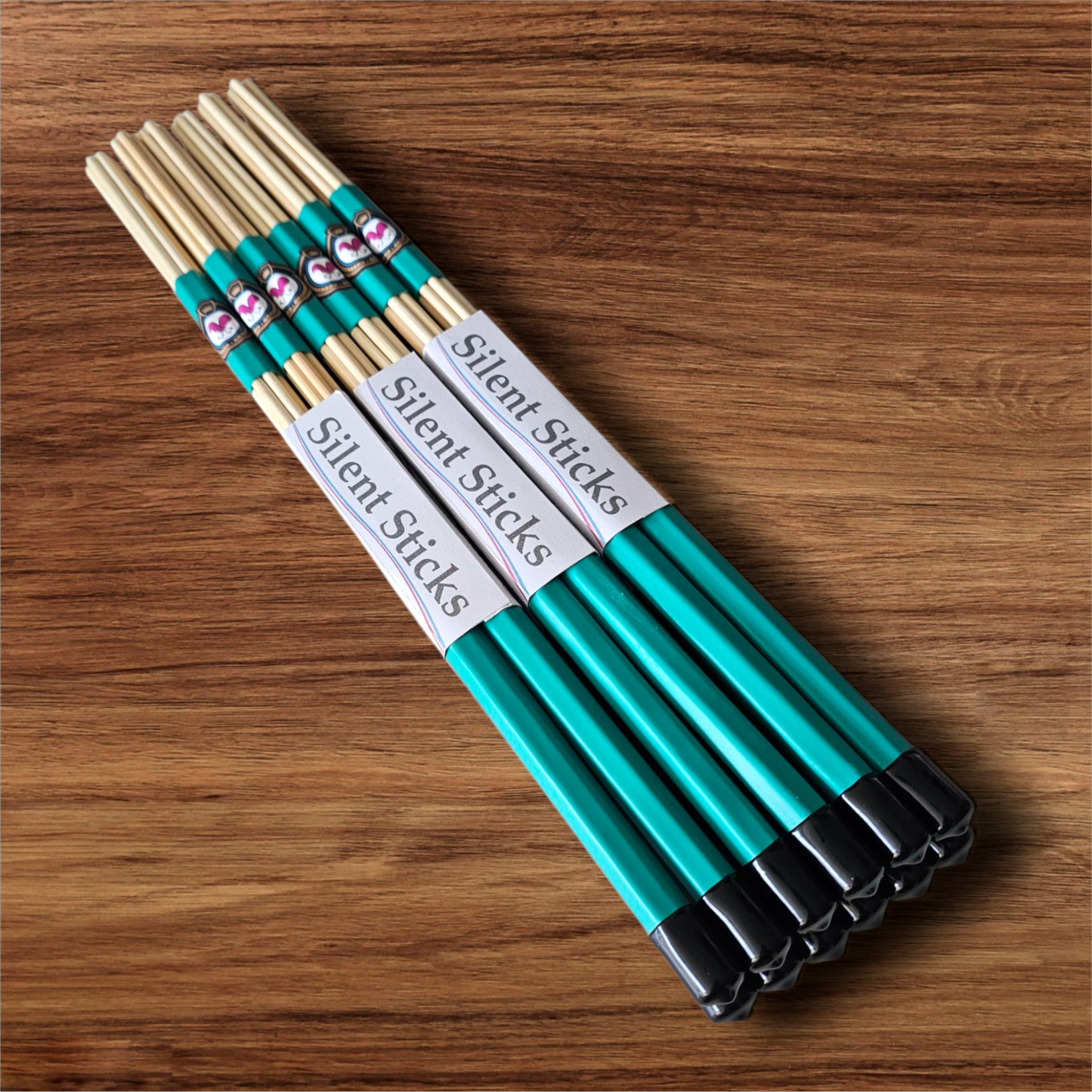 A brick containing 6 pairs of Silent Sticks 7-dowel hot rod drumsticks with green grip and black end caps. Low volume practice drum rods for apartments and low-volume acoustic gigs.