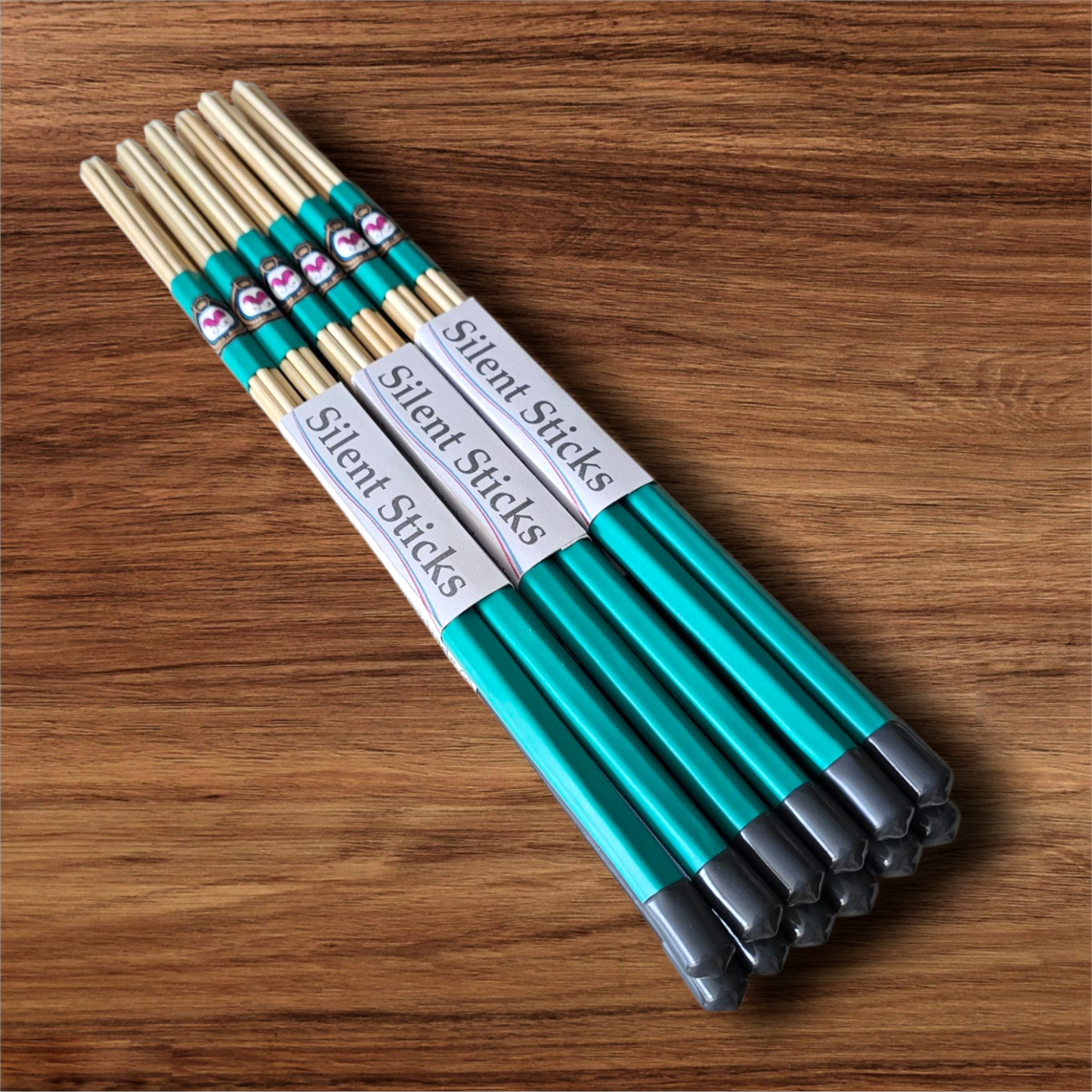 A brick containing 6 pairs of Silent Sticks 7-dowel hot rod drumsticks with green grip and grey end caps. Low volume practice drum rods for apartments and low-volume acoustic gigs.