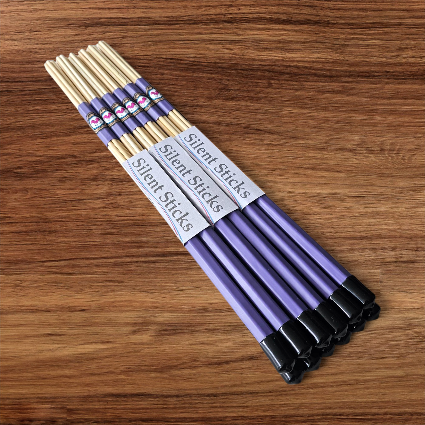 A brick containing 6 pairs of Silent Sticks 7-dowel hot rod drumsticks with purple grip and black end caps. Low volume practice drum rods for apartments and low-volume acoustic gigs.