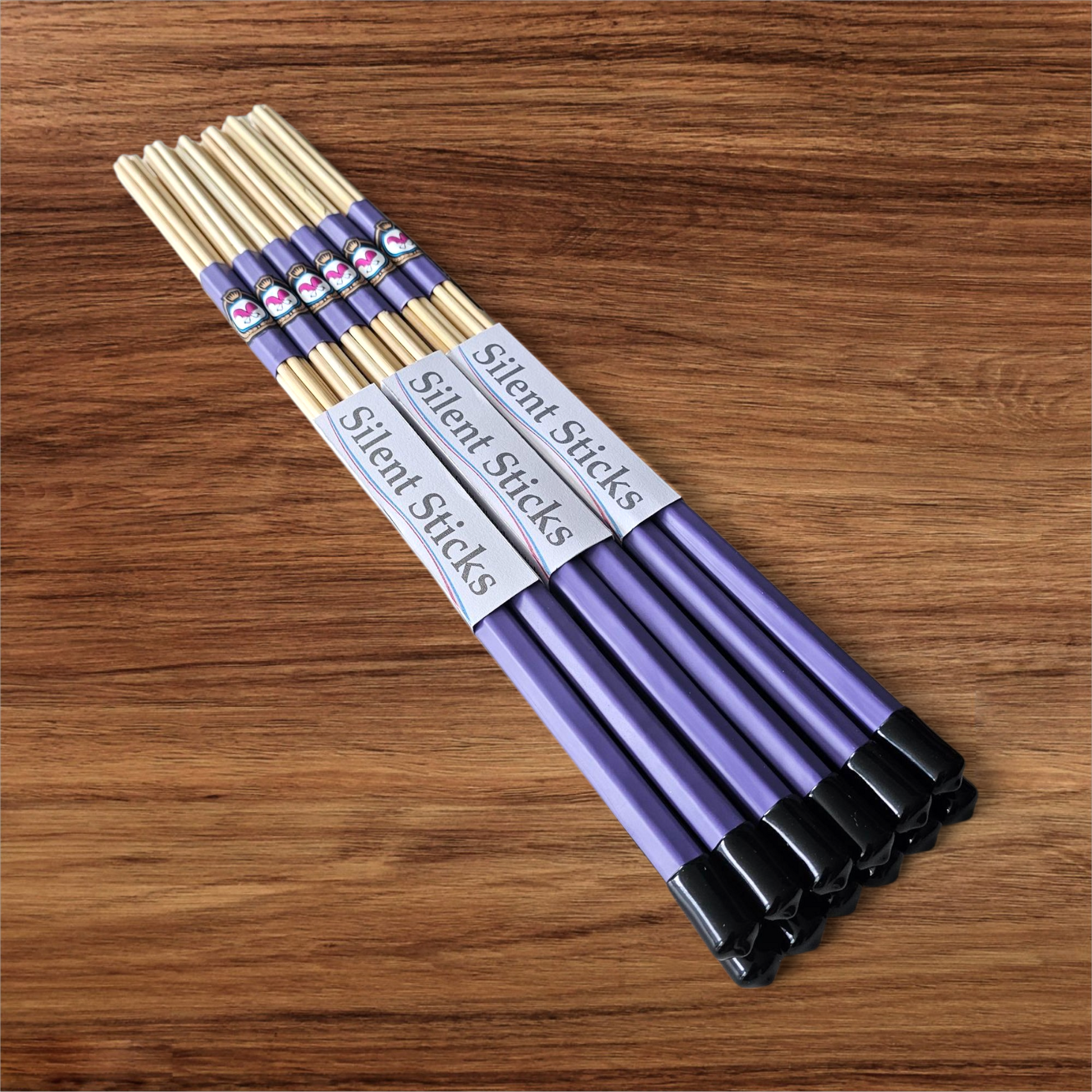A brick containing 6 pairs of Silent Sticks 7-dowel hot rod drumsticks with purple grip and black end caps. Low volume practice drum rods for apartments and low-volume acoustic gigs.