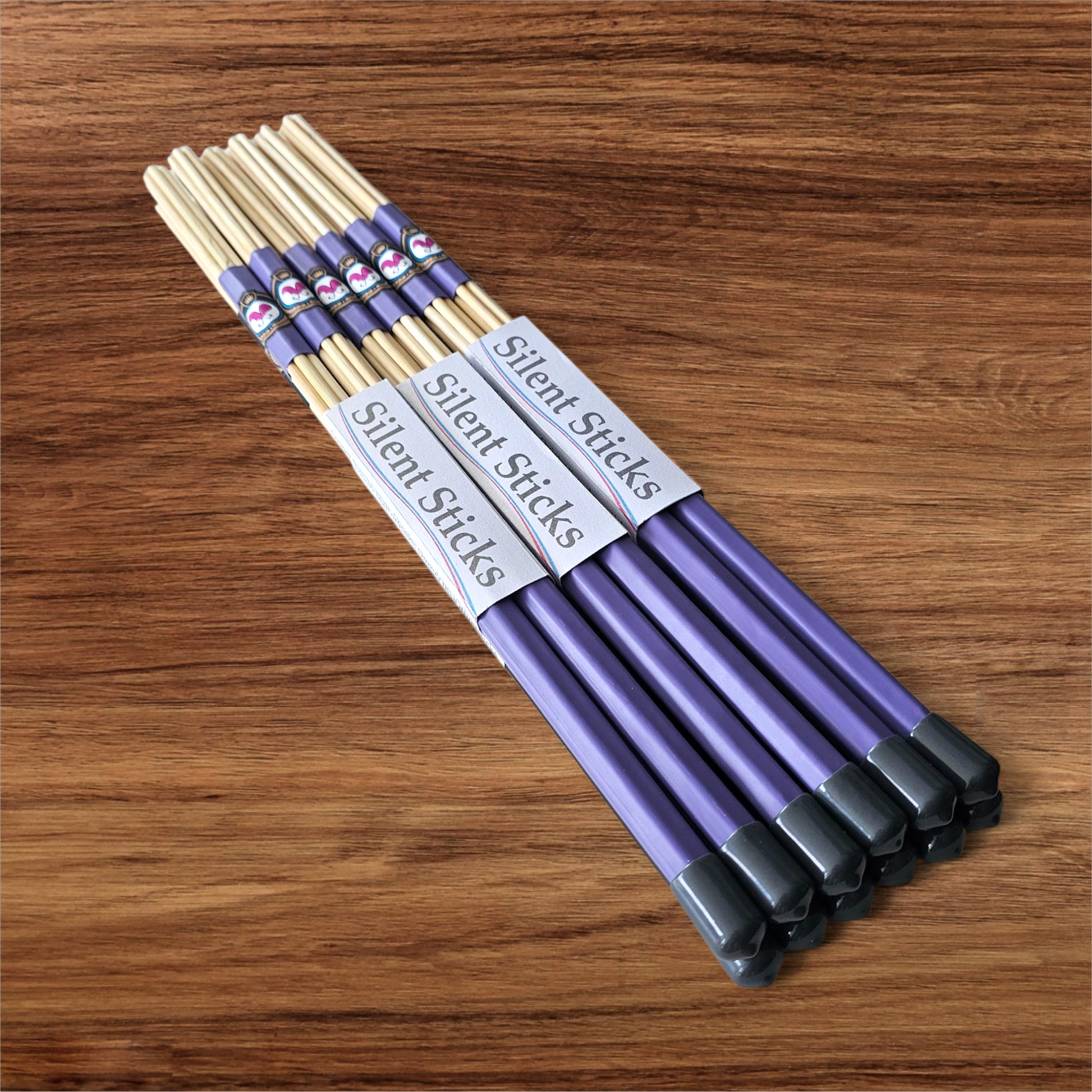 A brick containing 6 pairs of Silent Sticks 7-dowel hot rod drumsticks with purple grip and grey end caps. Low volume practice drum rods for apartments and low-volume acoustic gigs.