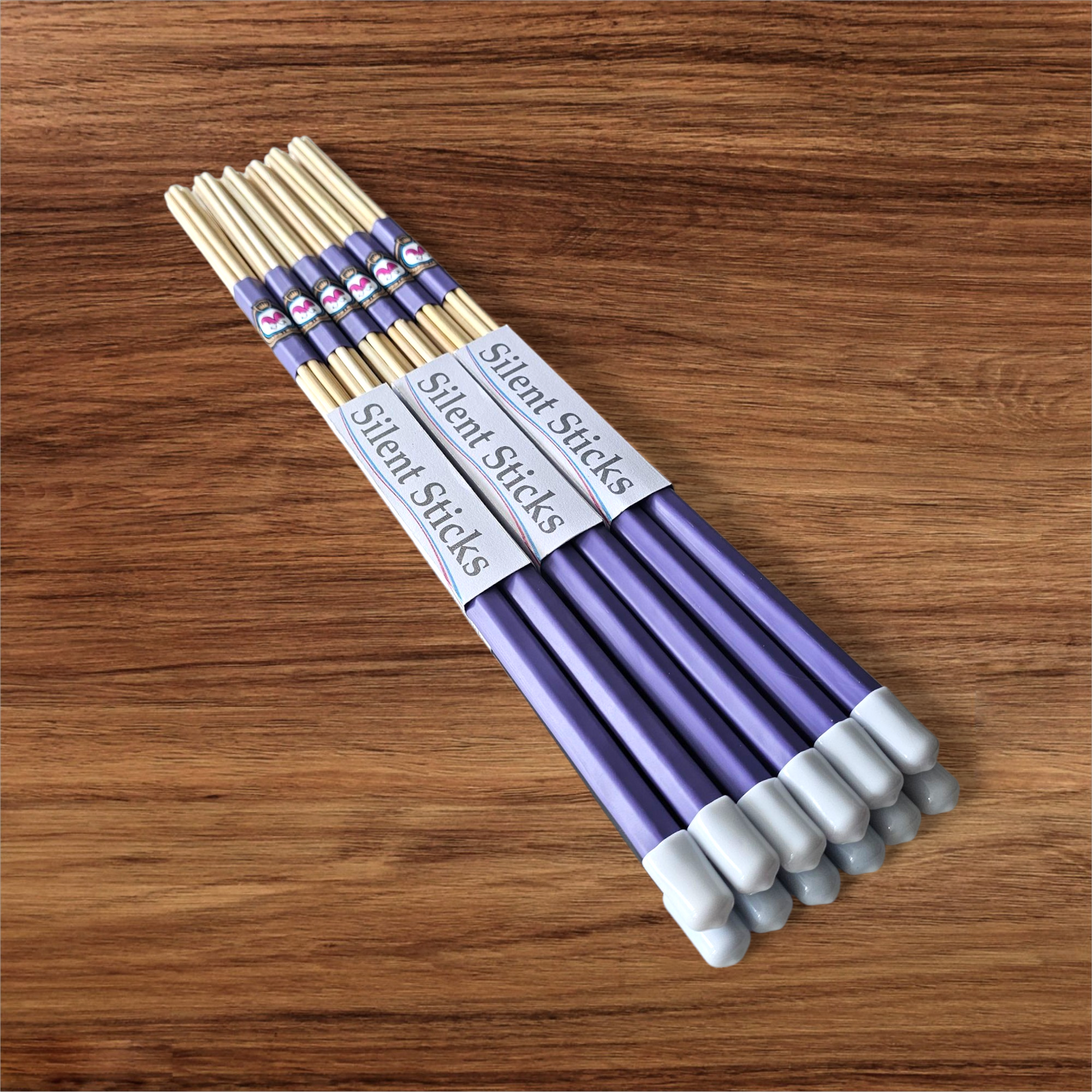 A brick containing 6 pairs of Silent Sticks 7-dowel hot rod drumsticks with purple grip and white end caps. Low volume practice drum rods for apartments and low-volume acoustic gigs.