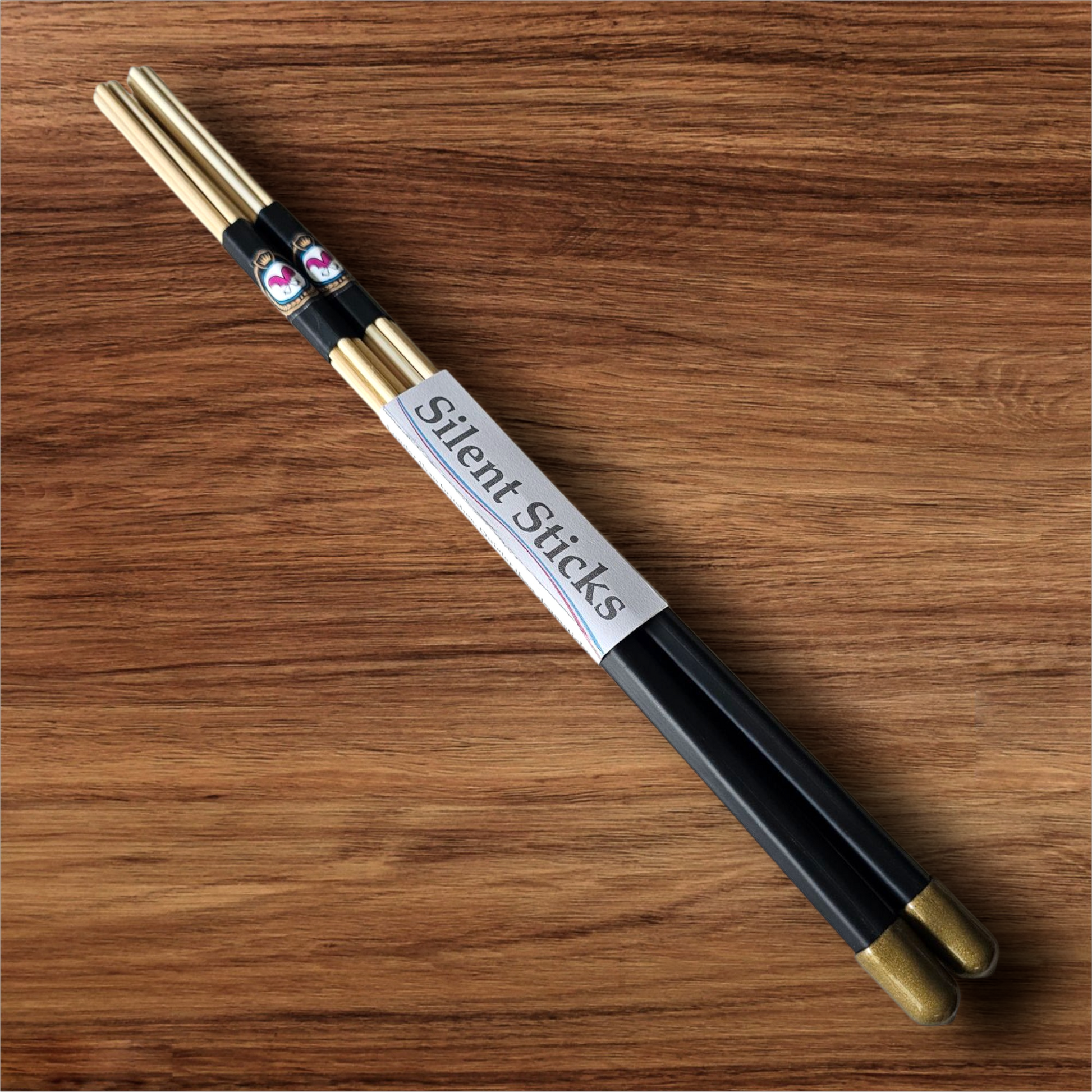A single pair of custom Silent Sticks 7-dowel hot rod drumsticks with black grip and gold end caps. Low volume practice drum rods for apartments and low-volume acoustic gigs.