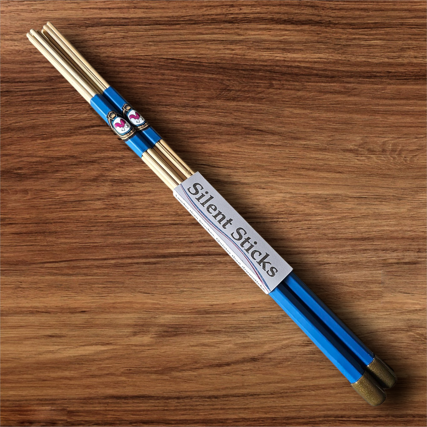 A single pair of custom Silent Sticks 7-dowel hot rod drumsticks with blue grip and gold end caps. Low volume practice drum rods for apartments and low-volume acoustic gigs.
