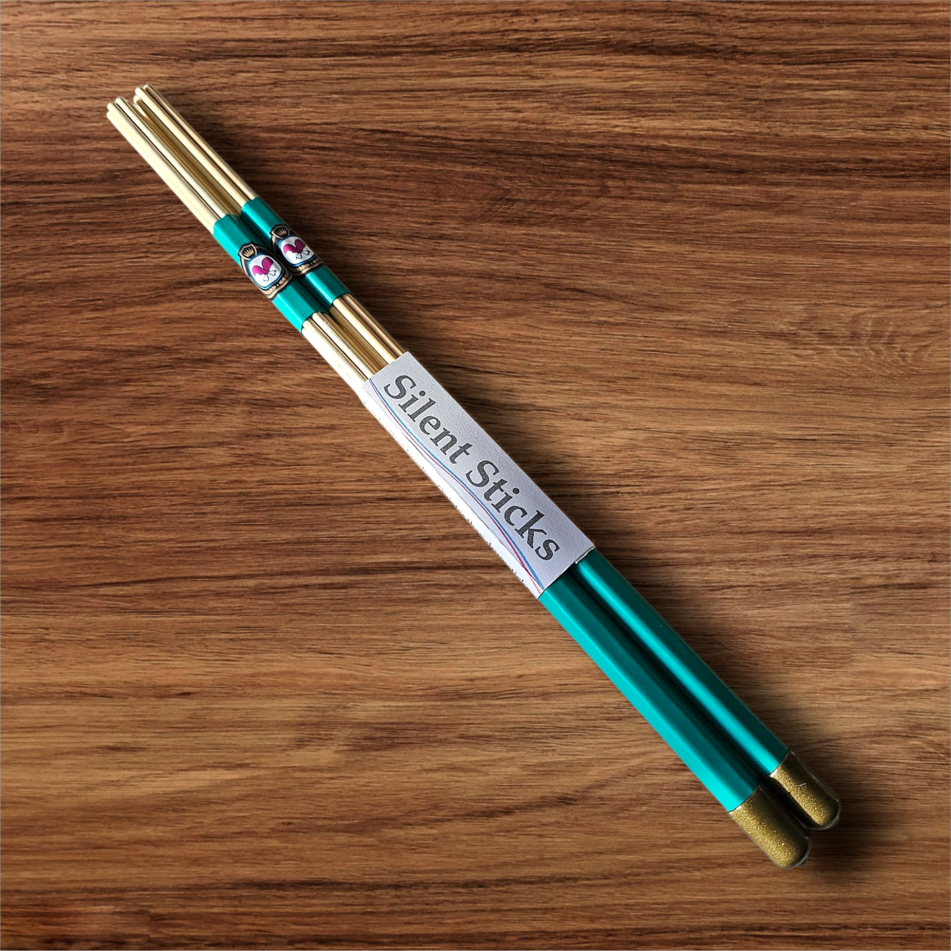 A single pair of custom Silent Sticks 7-dowel hot rod drumsticks with green grip and gold end caps. Low volume practice drum rods for apartments and low-volume acoustic gigs.