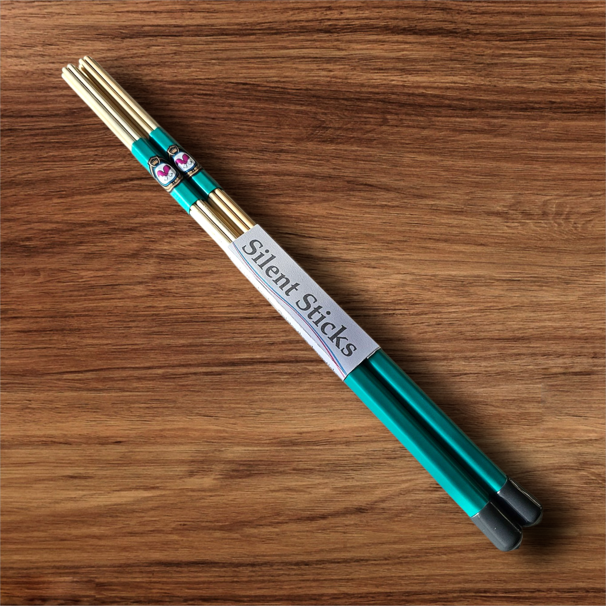 A single pair of custom Silent Sticks 7-dowel hot rod drumsticks with green grip and grey end caps. Low volume practice drum rods for apartments and low-volume acoustic gigs.