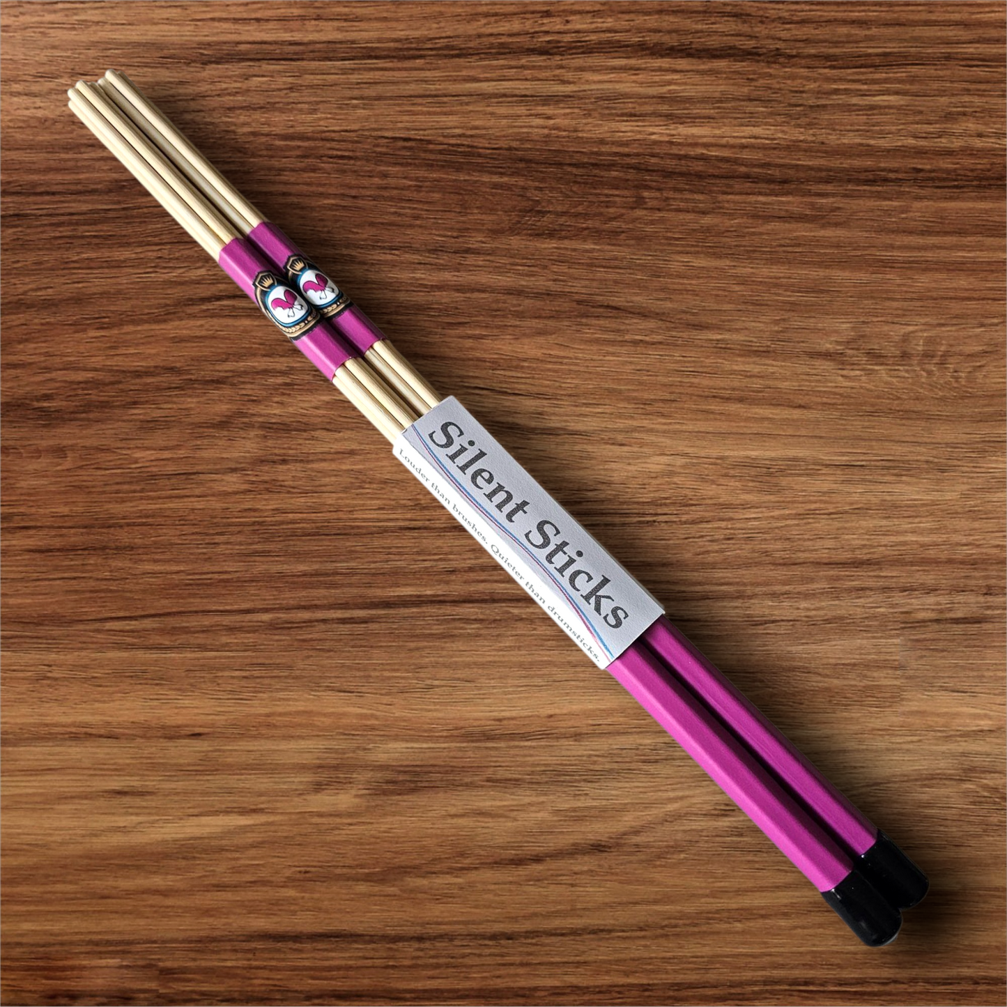 A single pair of custom Silent Sticks 7-dowel hot rod drumsticks with pink grip and black end caps. Low volume practice drum rods for apartments and low-volume acoustic gigs.