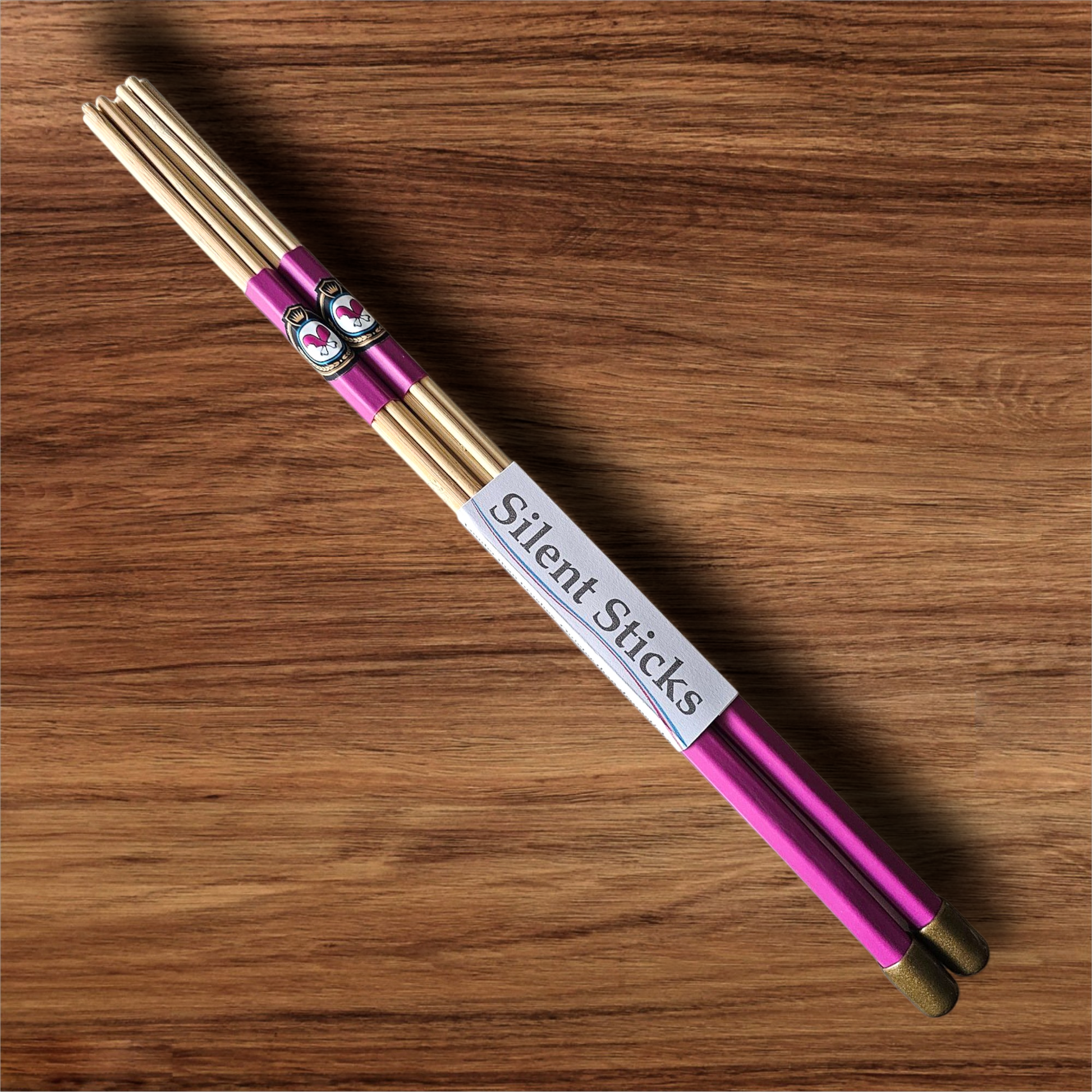 A single pair of custom Silent Sticks 7-dowel hot rod drumsticks with pink grip and gold end caps. Low volume practice drum rods for apartments and low-volume acoustic gigs.