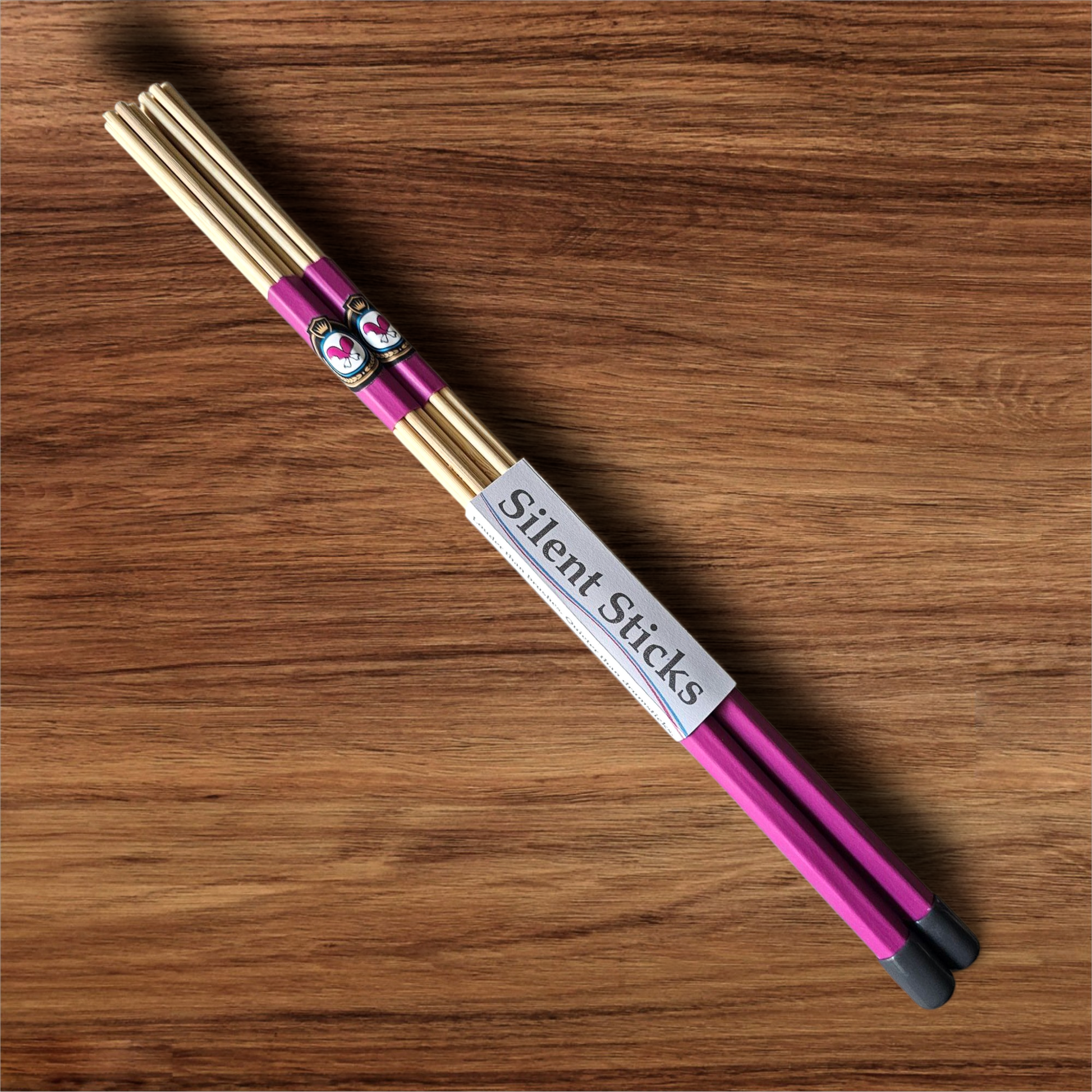A single pair of custom Silent Sticks 7-dowel hot rod drumsticks with pink grip and grey end caps. Low volume practice drum rods for apartments and low-volume acoustic gigs.