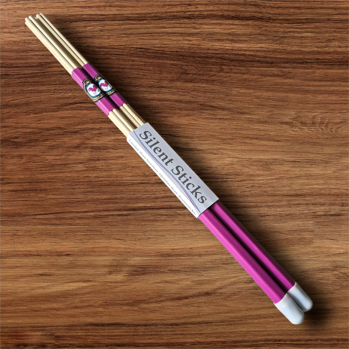 A single pair of custom Silent Sticks 7-dowel hot rod drumsticks with pink grip and white end caps. Low volume practice drum rods for apartments and low-volume acoustic gigs.