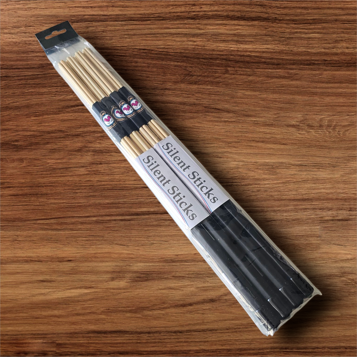 A package containing two pairs of custom Silent Sticks 7-dowel hot rod drumsticks with black grip and black end caps. Low volume practice drum rods for apartments and low-volume acoustic gigs.