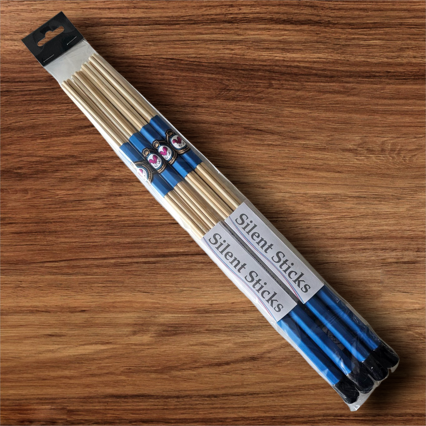 A package containing two pairs of custom Silent Sticks 7-dowel hot rod drumsticks with blue grip and black end caps. Low volume practice drum rods for apartments and low-volume acoustic gigs.