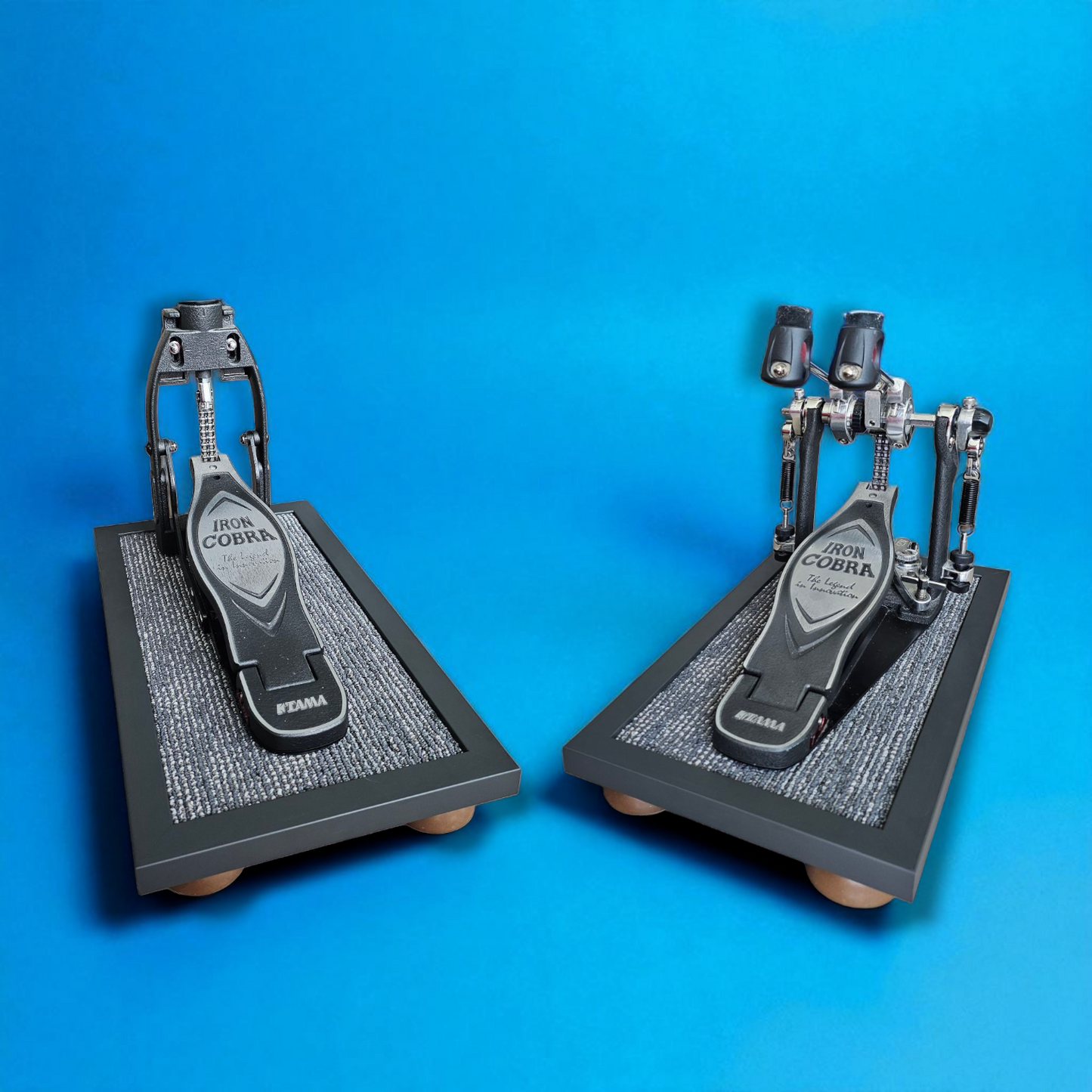 A pair of grey Silent Stomper impact noise isolation platforms (single pedal pack of two - for hi-hat pedals and bass drum pedals) designed for drummers, enabling quiet practice in enclosed spaces like apartment buildings by reducing vibrations and preventing noise disturbances/complaints for neighbors.