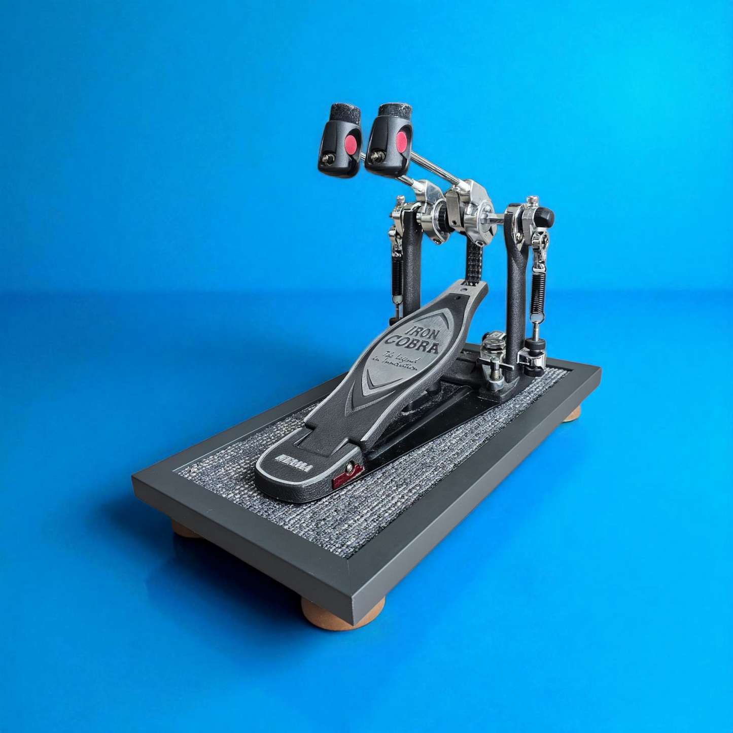 A grey Silent Stomper impact noise isolation platform (single pedal - for hi-hat pedals and bass drum pedals) designed for drummers, enabling quiet practice in enclosed spaces like apartment buildings by reducing vibrations and preventing noise disturbances/complaints for neighbors.