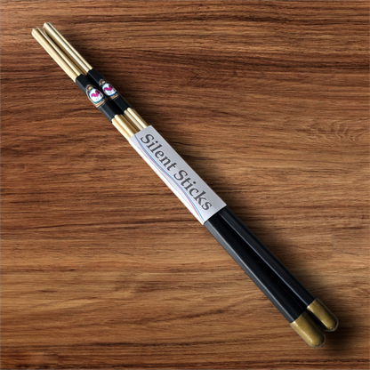 A single pair of custom Silent Sticks 7-dowel hot rod drumsticks with black grip and gold end caps. Low volume practice drum rods for apartments and low-volume acoustic gigs.