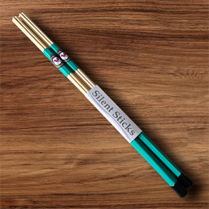 A single pair of custom Silent Sticks 7-dowel hot rod drumsticks with green grip and black end caps. Low volume practice drum rods for apartments and low-volume acoustic gigs.