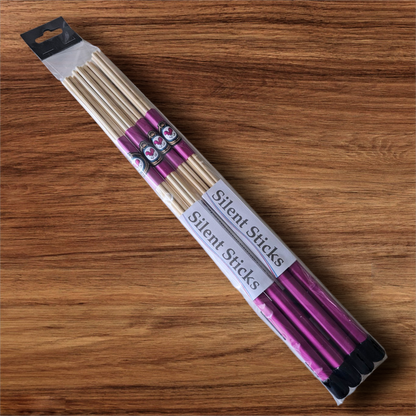 A package containing two pairs of custom Silent Sticks 7-dowel hot rod drumsticks with pink grip and black end caps. Low volume practice drum rods for apartments and low-volume acoustic gigs.