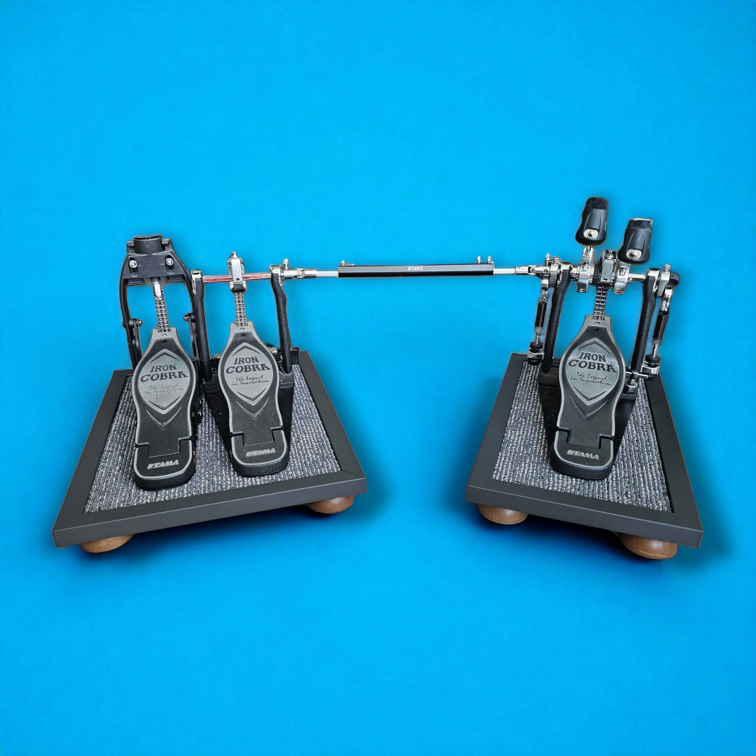 A pair of grey Silent Stomper impact noise isolation platforms (single pedal and double pedal pack - for hi-hat pedals and double bass drum pedals) designed for drummers, enabling quiet practice in enclosed spaces like apartment buildings by reducing vibrations and preventing noise disturbances/complaints for neighbors.